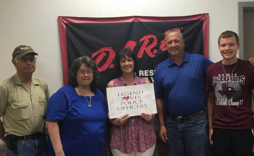 Image of five people standing in front of D.A.R.E. sign holding another sign saying, "Legend Loves Police Officers".
